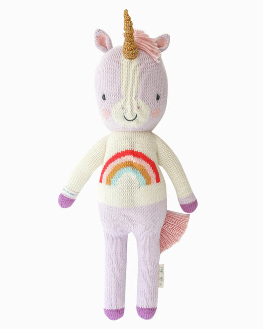 Knitted unicorn toy with a rainbow design on a white background