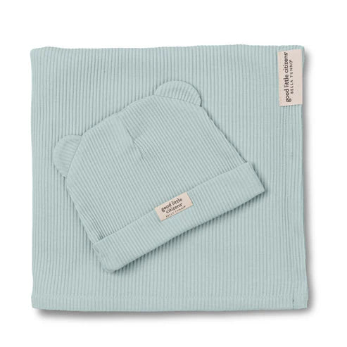 Light blue ribbed blanket and beanie set with 'good little company' label on a white background