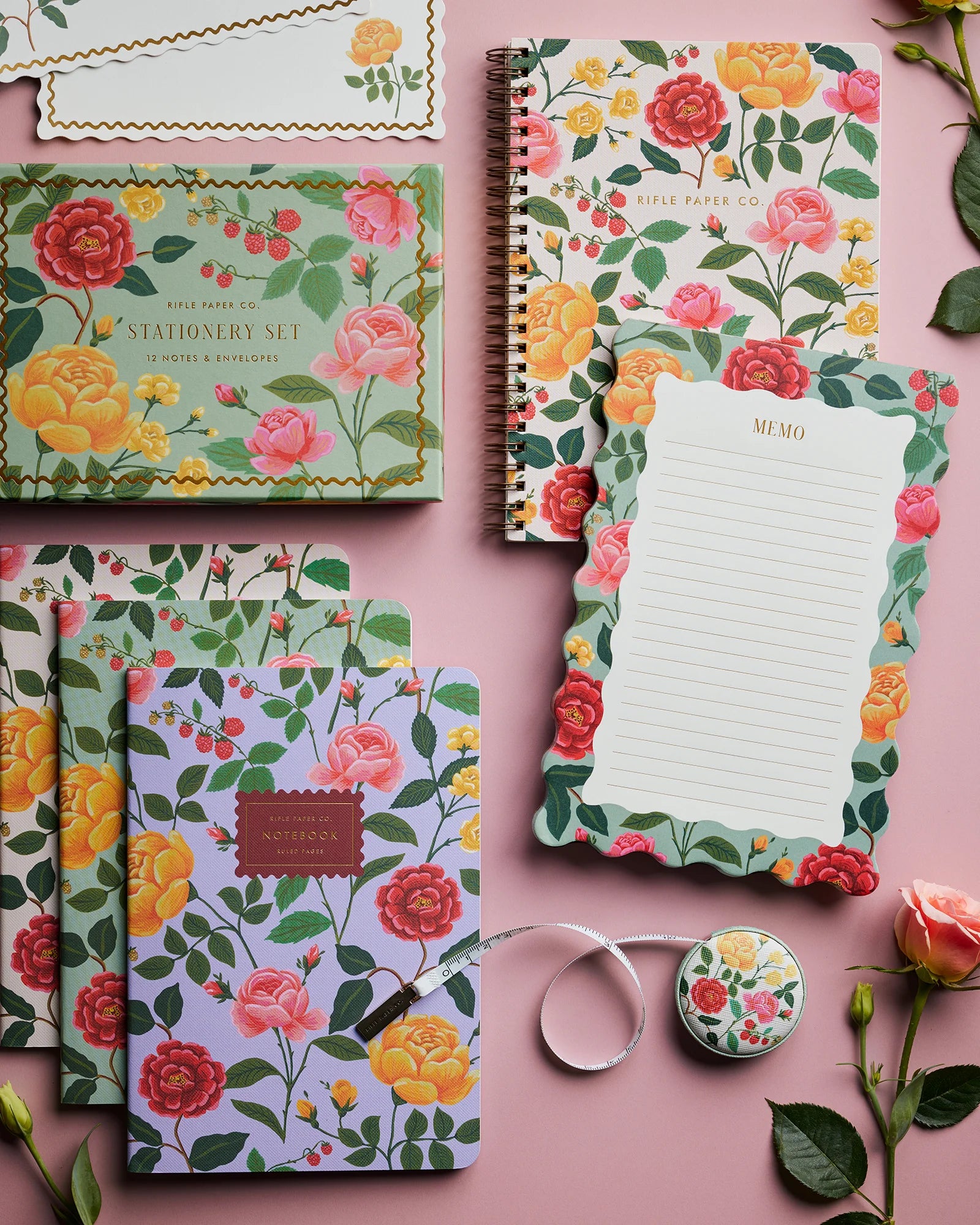 Floral notebook set on a pink background with stationery items.